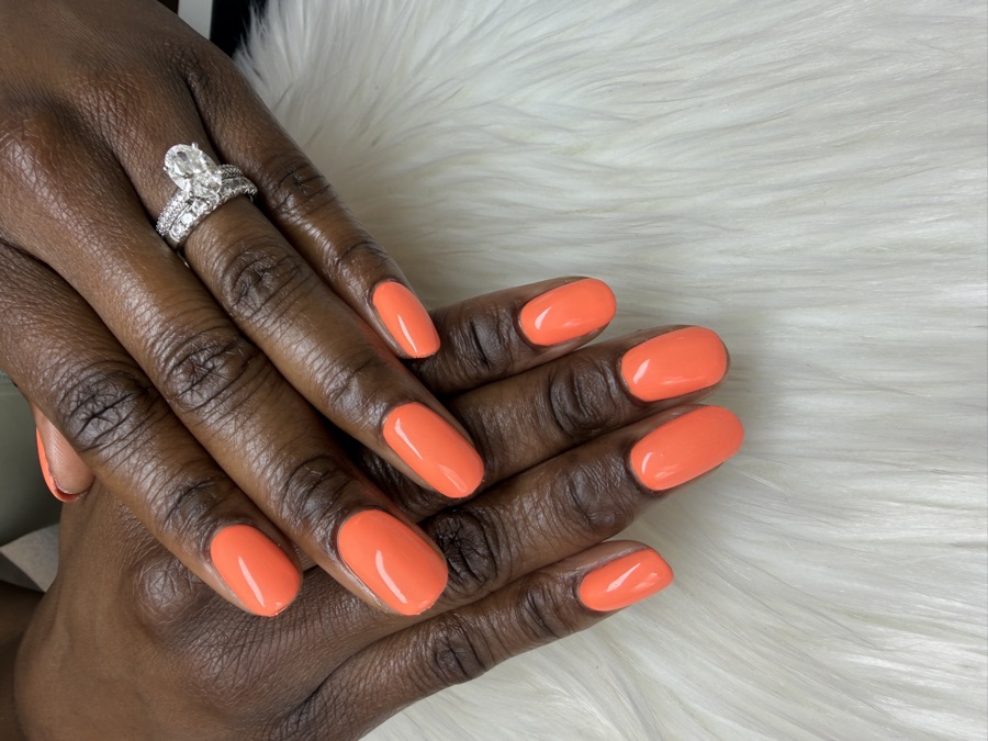 A glossy coral BIAB structured manicure by TLC Nails and Esthetics in Nottingham, MD