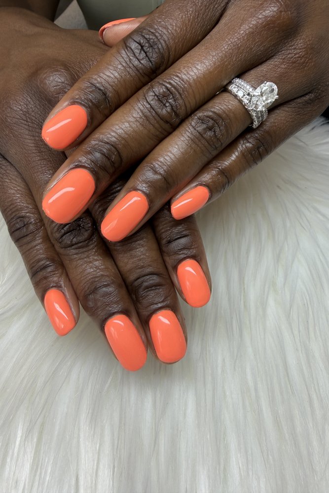 A finished glossy orange BIAB manicure at TLC Nails and Esthetics, the builder in a bottle nail salon in Nottingham, MD