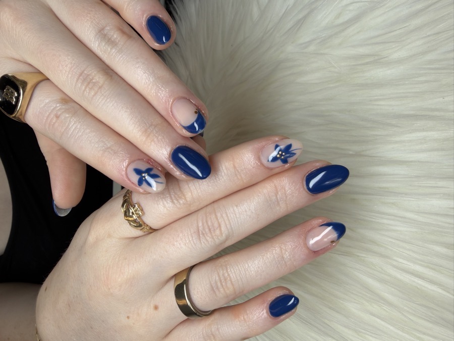 Navy blue BIAB nails with hand-painted white floral art and gold studs by TLC Nails and Esthetics in Nottingham, MD