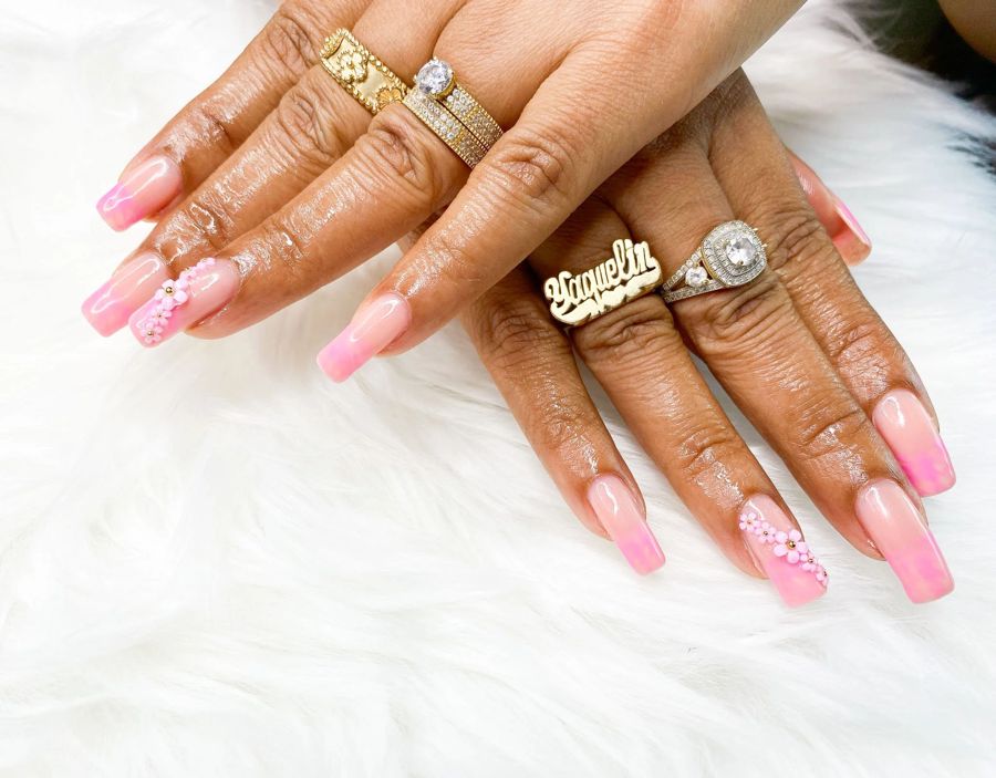 Long pink square nails with gold charm accents by the private nail salon TLC Nails and Esthetics