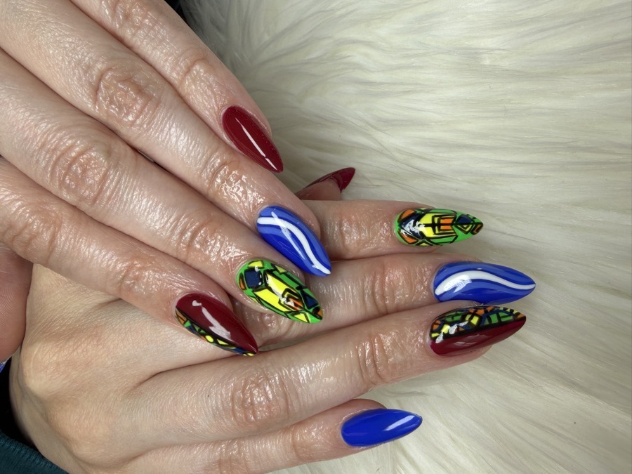 Stiletto Gel X nails with bold hand-painted red, blue, and green stained-glass style art by TLC Nails and Esthetics in Nottingham, MD