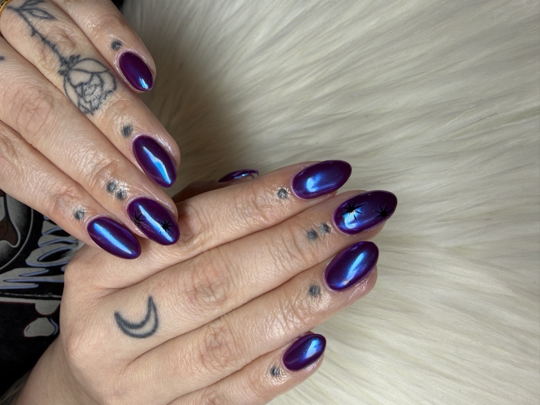 Long almond-shaped Hard Gel nails with a chrome purple finish and star accents by TLC Nails and Esthetics in Nottingham, MD