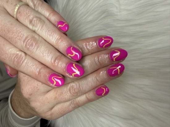 A magenta Hard Gel manicure with hand-painted yellow swirl line art by TLC Nails and Esthetics in Nottingham, MD
