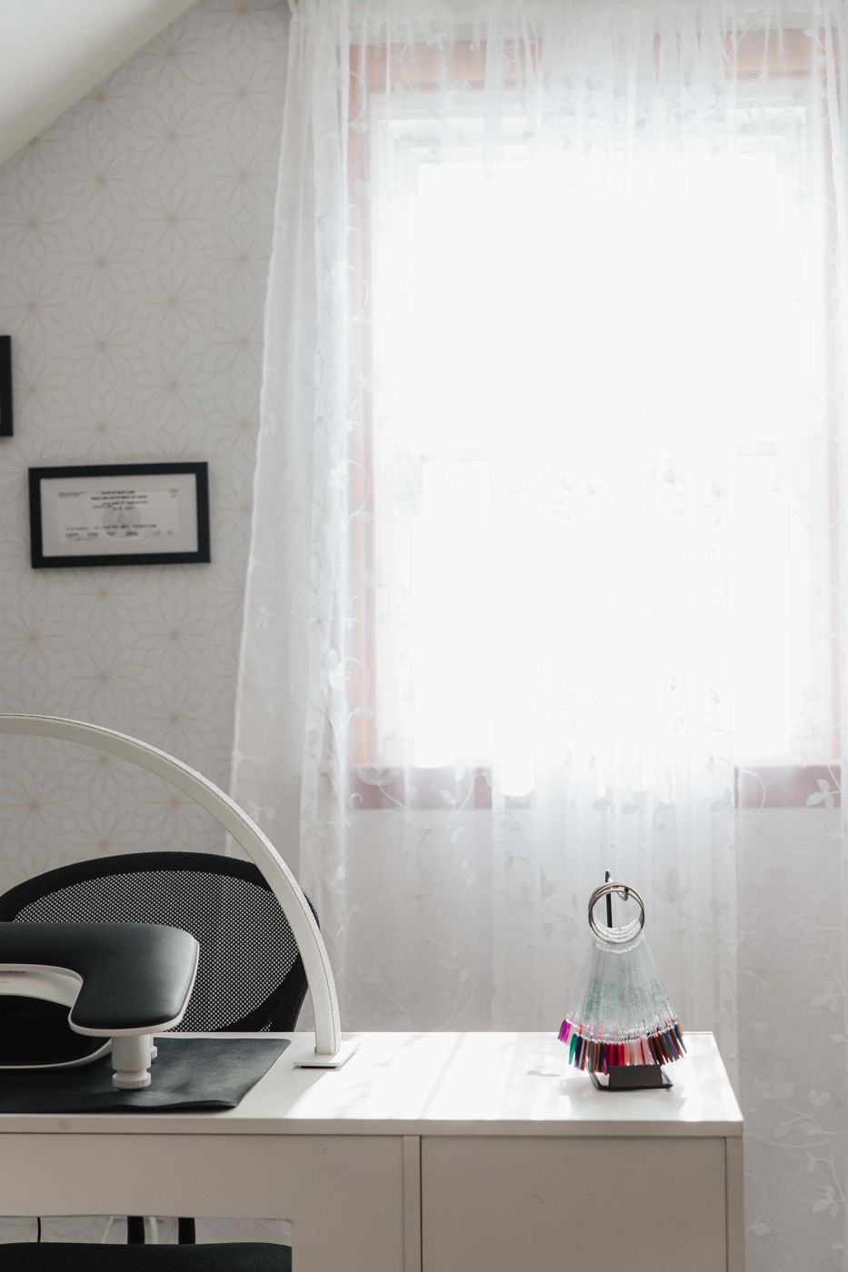 The private one client suite at TLC Nails and Esthetics in Nottingham, MD, with the framed Maryland license, gel polish swatch fan and ring lamp at the station where nail removal appointments happen