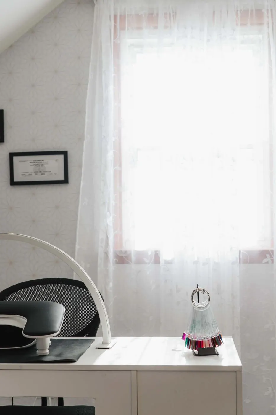 The private one client suite at TLC Nails and Esthetics in Nottingham, MD, with the framed Maryland license, gel polish swatch fan and ring lamp at the station where nail removal appointments happen