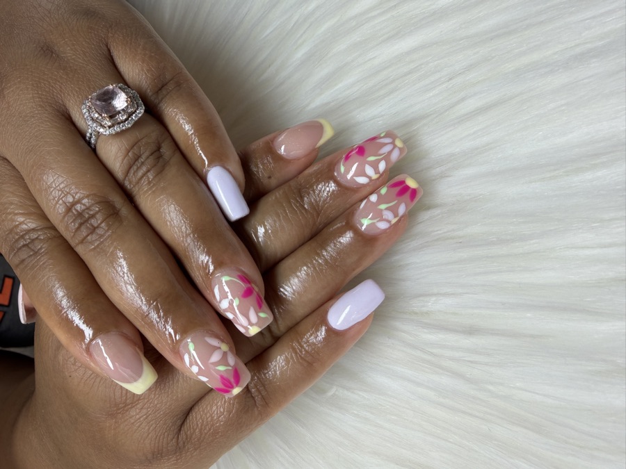 A nude gel set with hand-painted pink florals and yellow tip accents, part of a spa package at TLC Nails and Esthetics in Nottingham, MD