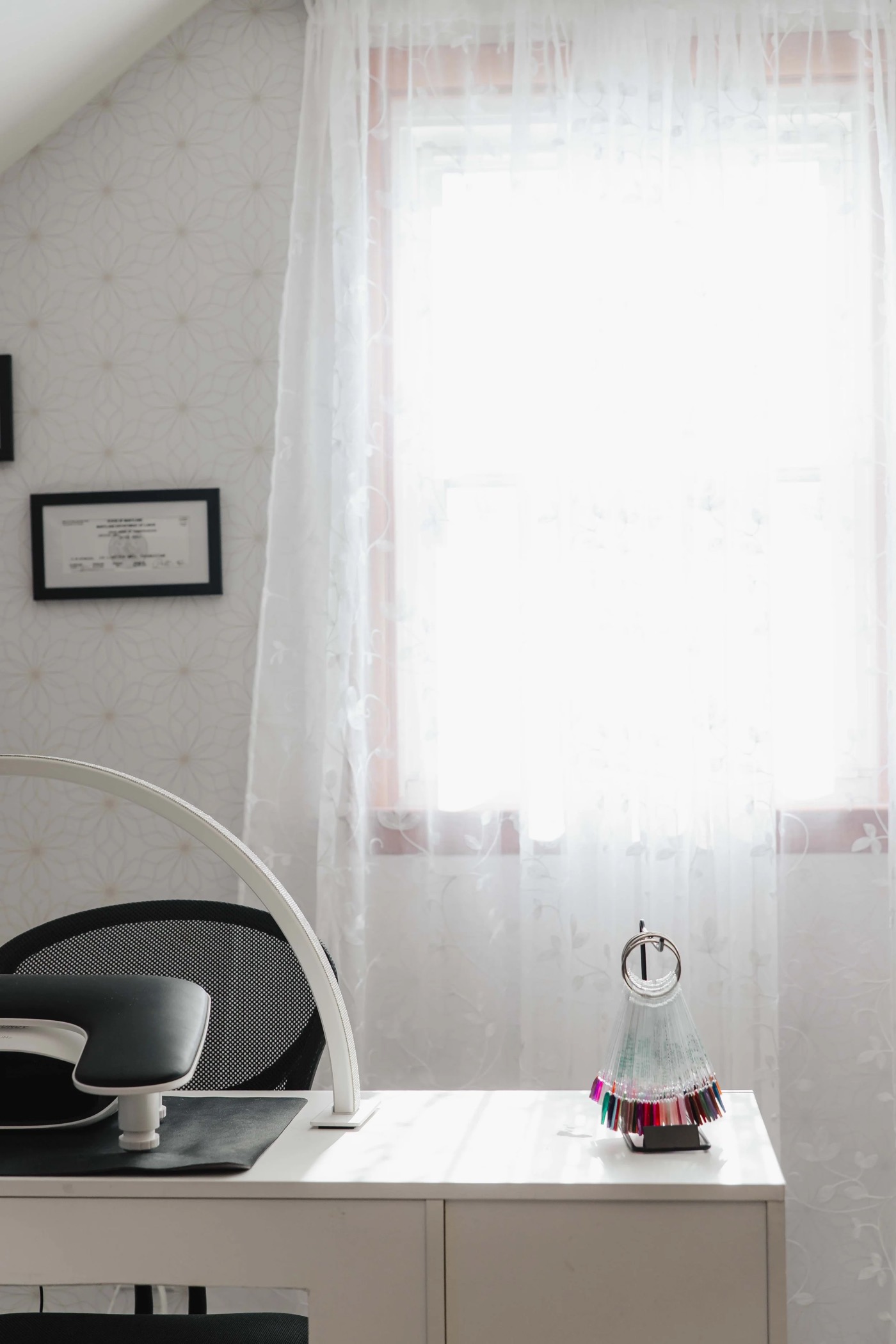 The private nail salon suite at TLC Nails and Esthetics in Nottingham, MD, with the manicure table, lamp, polish swatch fan, and the Maryland license framed on the wall